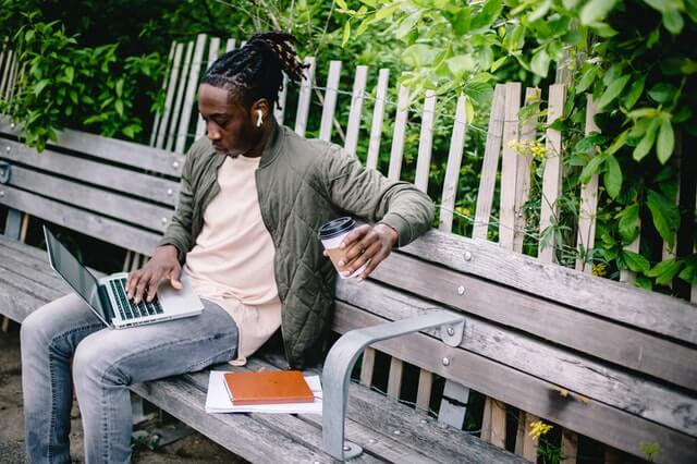 man working with laptop on a bench