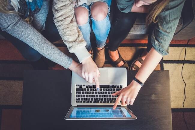 people pointing at laptop e-learning